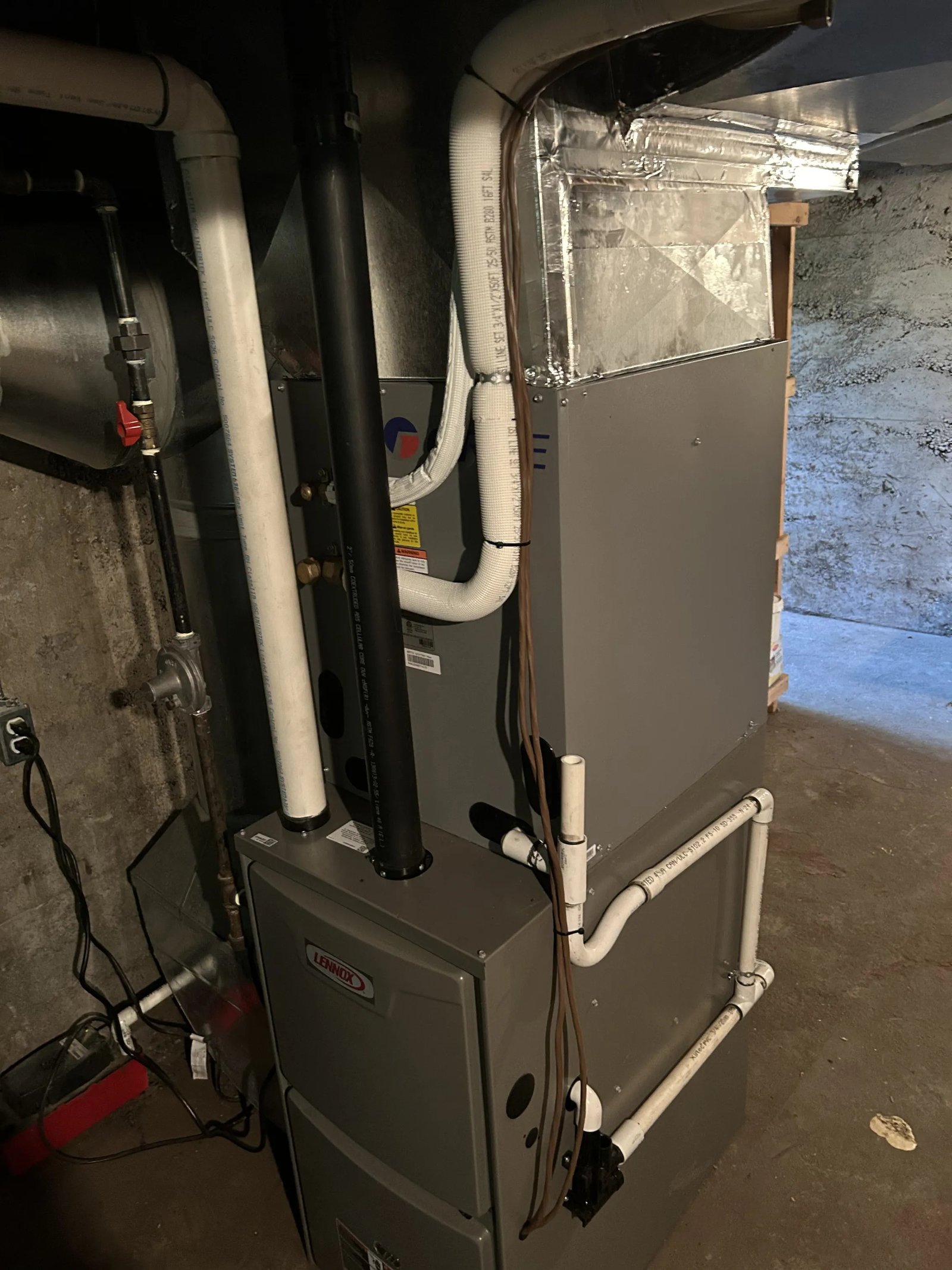 Gas furnace installed in a mechanical closet with ductwork and venting