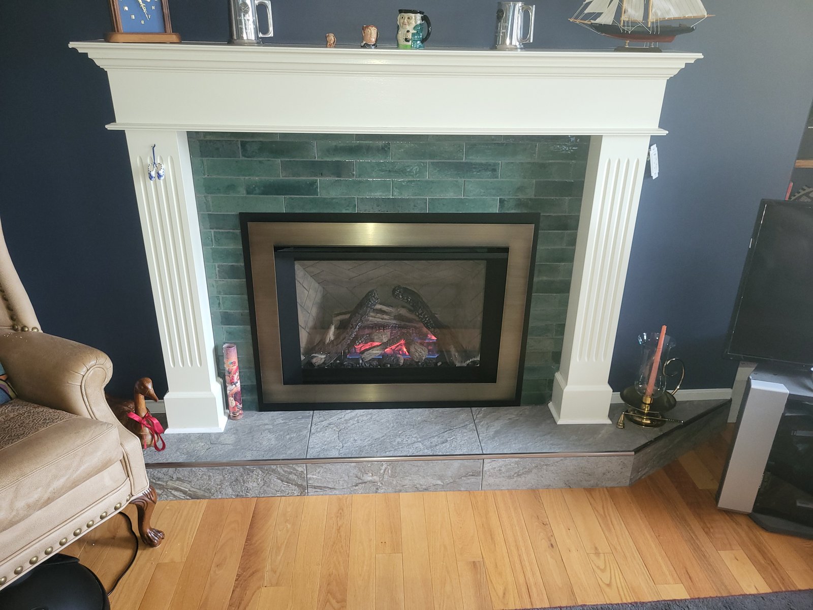 Gas fireplace insert in a green tile surround