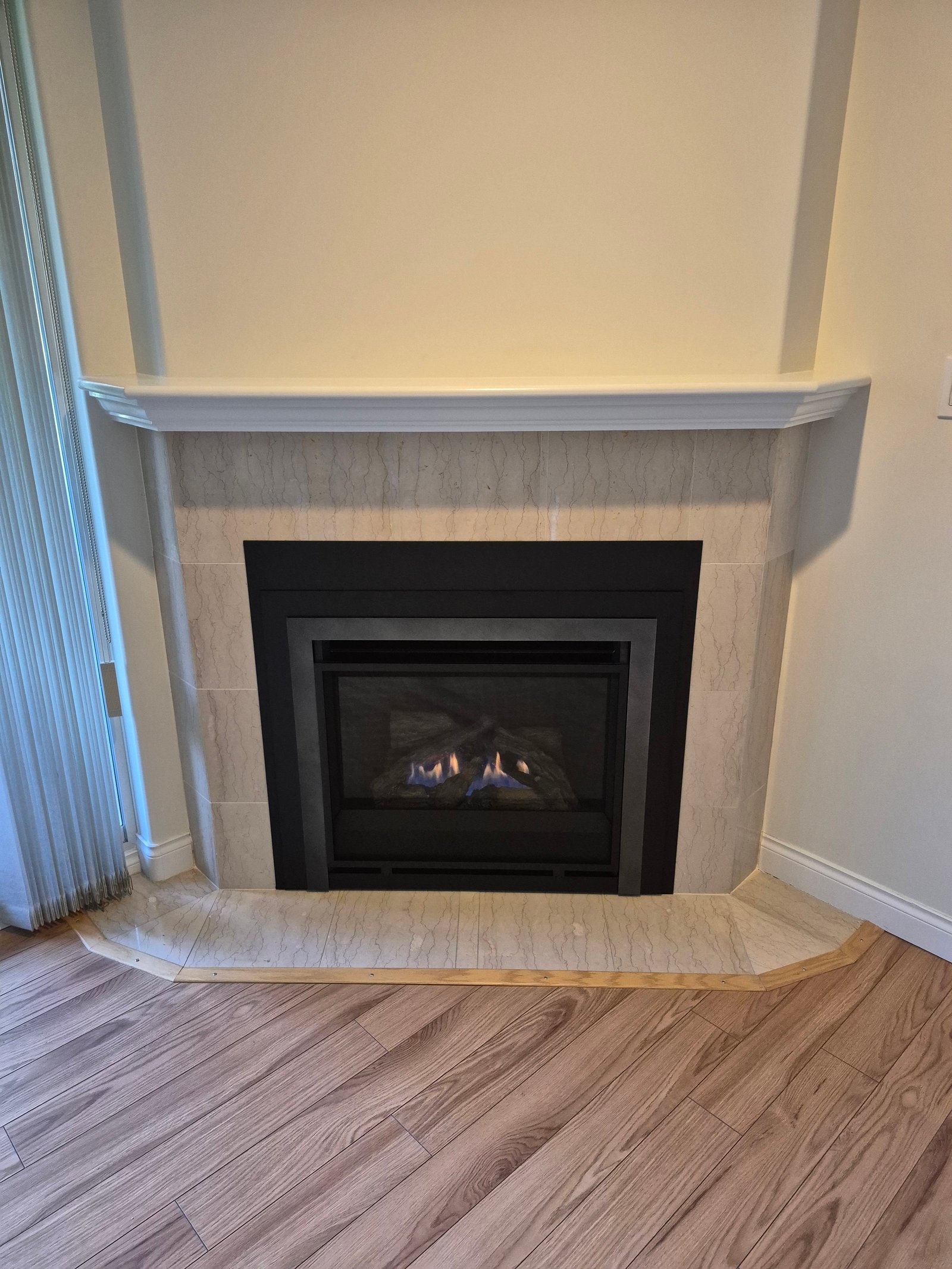 Gas fireplace insert in a cream marble surround