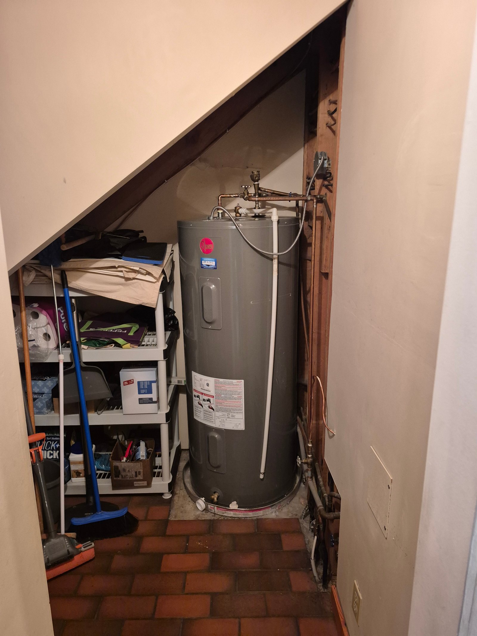 Electric hot water tank installed under a staircase