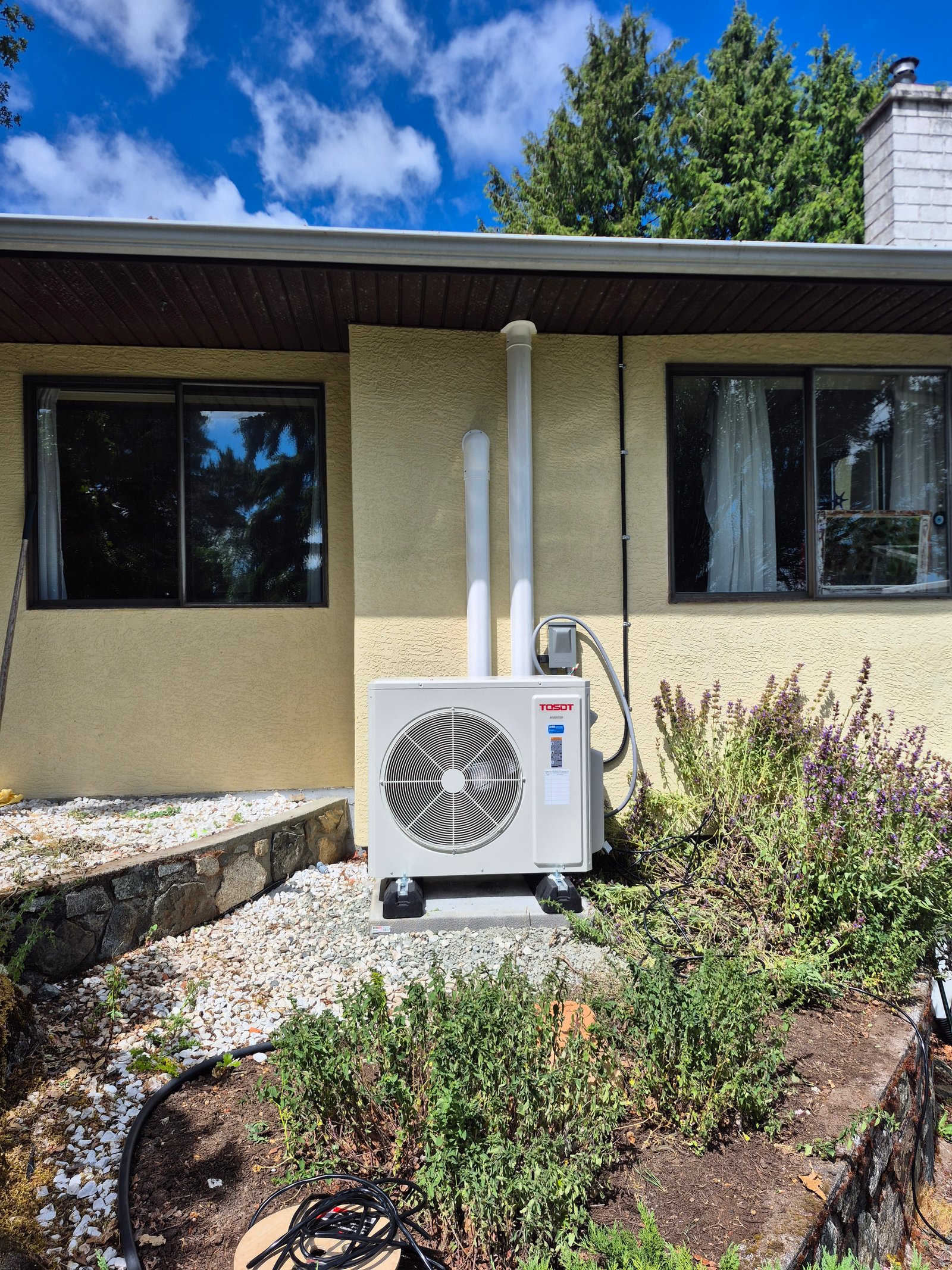 Outdoor heat pump condenser unit installed beside a home