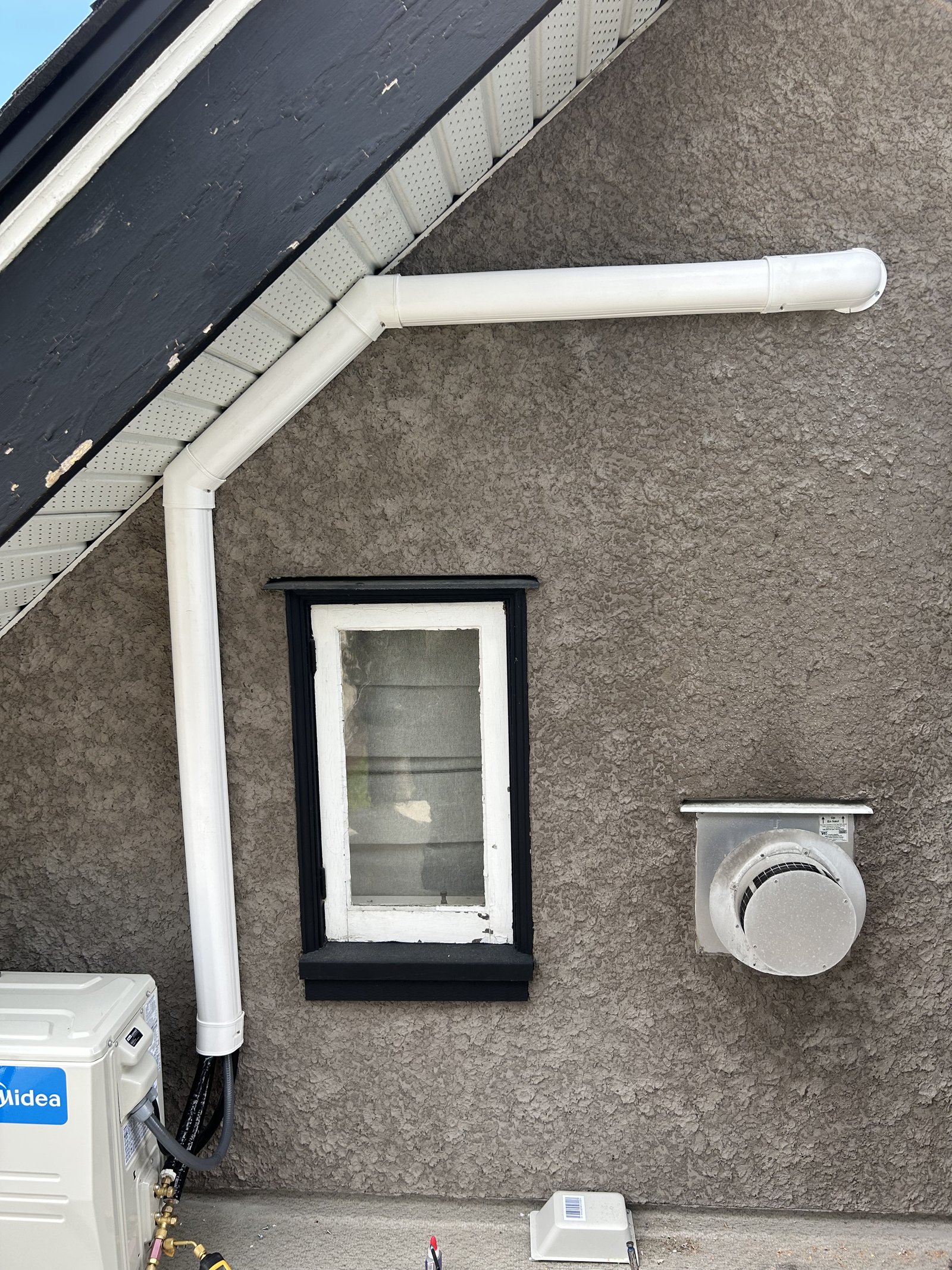 Heat pump refrigerant line set and condensate vent routed along an exterior wall